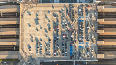 Large parking lot with cars in Krakow, Poland. Railway station under parking lot. Drone flight view