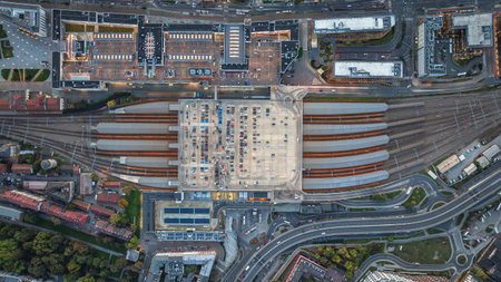 Aerial view of Krakow s main station at dusk, showing illuminated platforms, parking rooftop and...