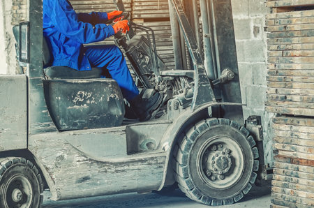 Confident woman operating forklift inside industrial warehouse. Concept of female empowerment, professionalism, and breaking gender stereotypes in heavy industry.の写真素材