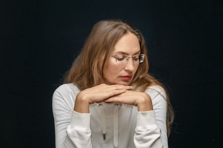 Thoughtful woman in glasses with calm introspective expression, psychological portrait reflection,...