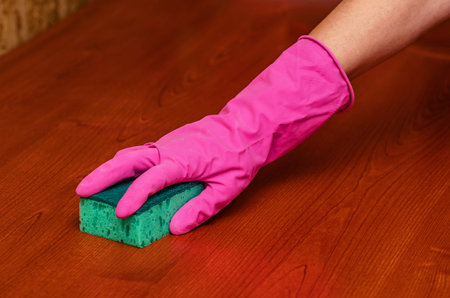 Close-up of professional cleaner disinfecting office furniture using cloth. Corporate hygiene, clean...
