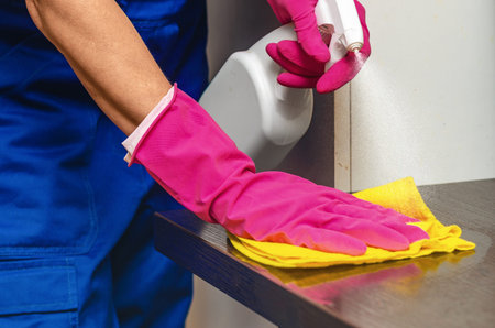 Ordering professional cleaner, disinfecting office furniture using spray and rag. Concept of...