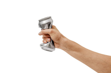 Crumpled aluminum beverage can in person's hand, isolated on white background. Minimalist studio...