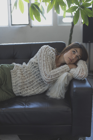 Portrait of a young woman sleeping on a sofaの写真素材