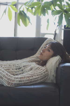 Portrait of a young woman sleeping on a sofaの写真素材