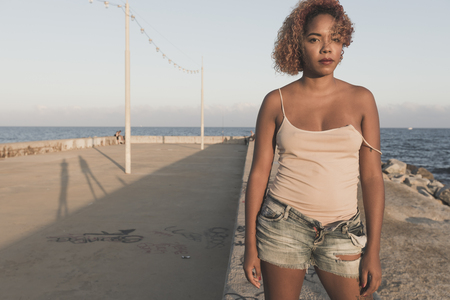 African American woman standup in shorts at Barcelona Beachの写真素材