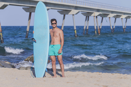 Surfer holding his blue surfboard