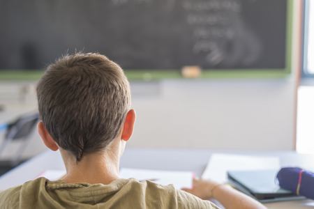 Daily day in a class room at school. Child attending to the lesson on the blackboard