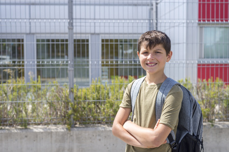 Cheerful child carrying his backpackの写真素材