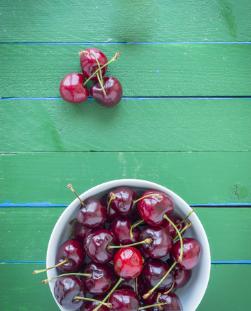 Ripe cherries on wooden table. View from above with copy space