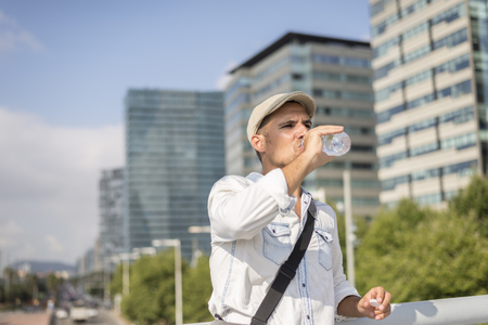 Young and masculine man drinking a water outsideの写真素材