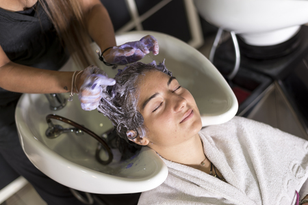 Young woman washing hair in salon ( hairdresser concept )の写真素材