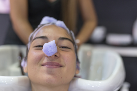 Young woman washing hair in salon ( hairdresser concept )の写真素材