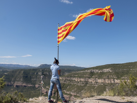 Woman on top of a mountain with Catalonian flagの写真素材
