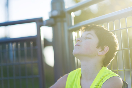 Portrait of a teen relaxing and dreaming on a basketball court with sunlight effectの写真素材