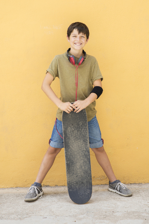 A Teen with skateboard on the city street ( Headphone around neck )の写真素材
