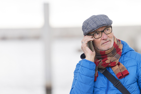 Mature man talking phone on streetの写真素材