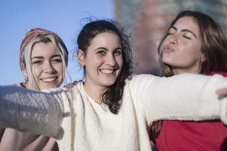 Lifestyle sunny image of best friend girls taking selfie on camera, crazy emotions , happy vacations, shopping day.の写真素材