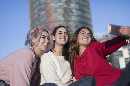 Lifestyle sunny image of best friend girls taking selfie on camera, crazy emotions , happy vacations, shopping day.の写真素材