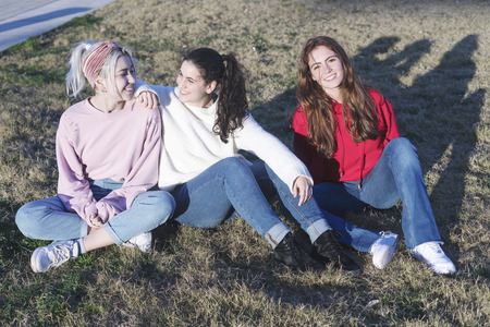 Three happy teenage friends having fun in spring park