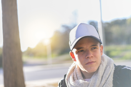 Portrait of a young handsome smiling man wearing a cap outdoorsの写真素材