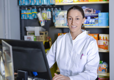 Young female pharmacist working on computerの写真素材