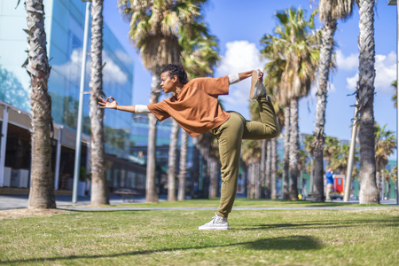 Black woman, afro hairstyle, doing yoga asana in promenadeの写真素材