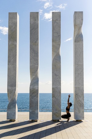 Portrait of young woman doing yoga exercise on seaside