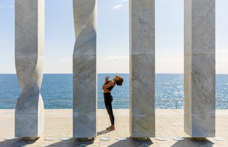 Portrait of young woman doing yoga exercise on seaside