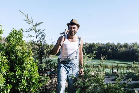 Smiling young farmer man standing in the garden while looking awayの写真素材