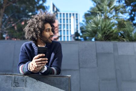 Portrait of handsome afro man using his mobile.