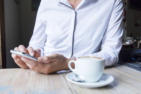 Female using app on a smart phone.Sitting in the cafe.の写真素材