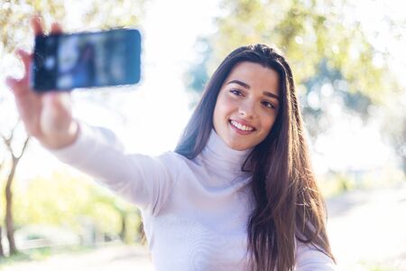 Beautiful young woman taking a self portrait