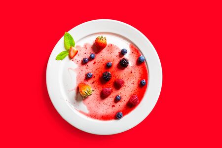Strawberries and blackberries on defrosted over a ed backgroundの写真素材