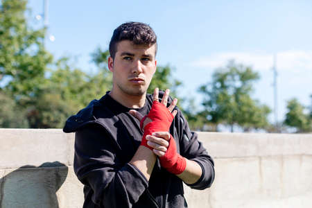 Boxer preparing for training with forearm bandage outdoorsの写真素材