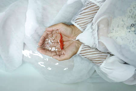 Woman's hands in bathtub with water red goldfish in her palms. Closeup.の写真素材