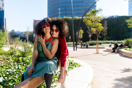 Smiling couple embracing and relaxing on a park benchの写真素材