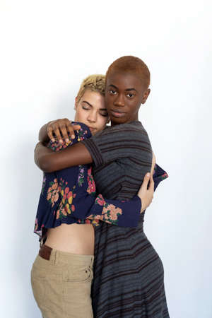 Photo of joyful ladies embrace and enjoy togetherness, being of different races, dressed in casual...