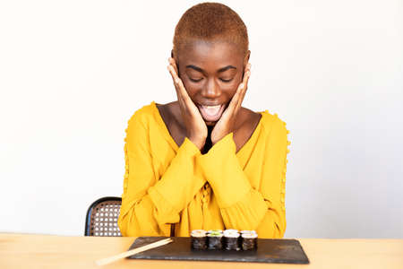 Portrait of surprised young African American woman looking down with hands cupped around mouth