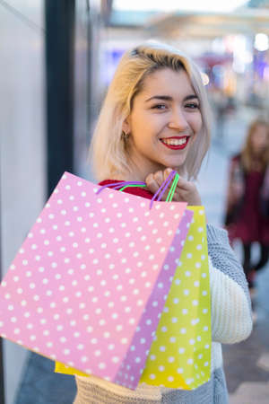 Woman in shopping. Happy woman with shopping bags enjoying in shopping. Consumerism, shopping, lifestyle conceptの写真素材