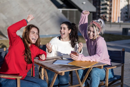 Overjoyed female students celebrating successful final testsの写真素材