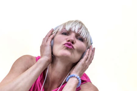 blonde girl with headphones kissing at camera