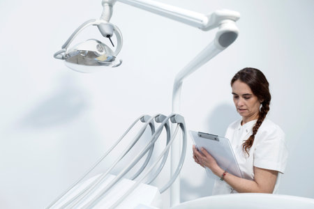 Confident experienced qualified happy smiling doctor holding clipboard with documentsの写真素材