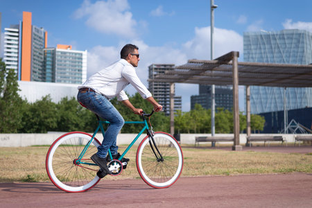 young man riding fixed gear bike on city streetの写真素材