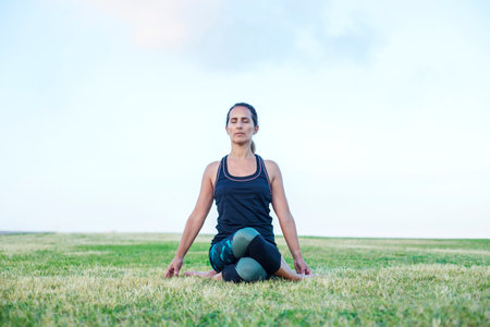 Beautiful girl is engaged in yoga in the parkの写真素材