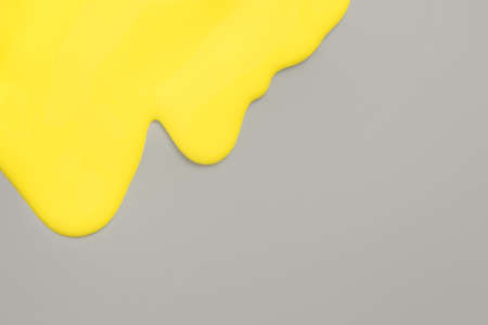 Yellow color melting on gray background. Minimal layout concept with copy space.の写真素材