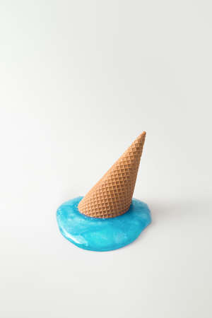 Overhead turquoise blue melting ice cream on gray background. Minimalistic summer food concept.