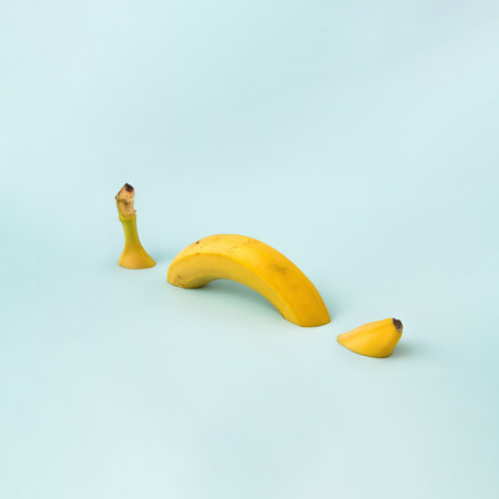 Summer sliced yellow banana on gray beckground. Minimal food concept.の写真素材