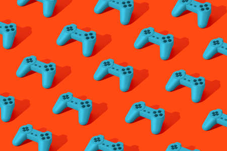 Pattern made with blue gamepad joystick on orange background. Minimal creative idea of technology. Flat lay. 3d render.の写真素材