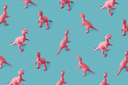 Creative isometric pink painted dinosaur toy pattern on blue background.  Minimal abstract concept for school and kids.の写真素材